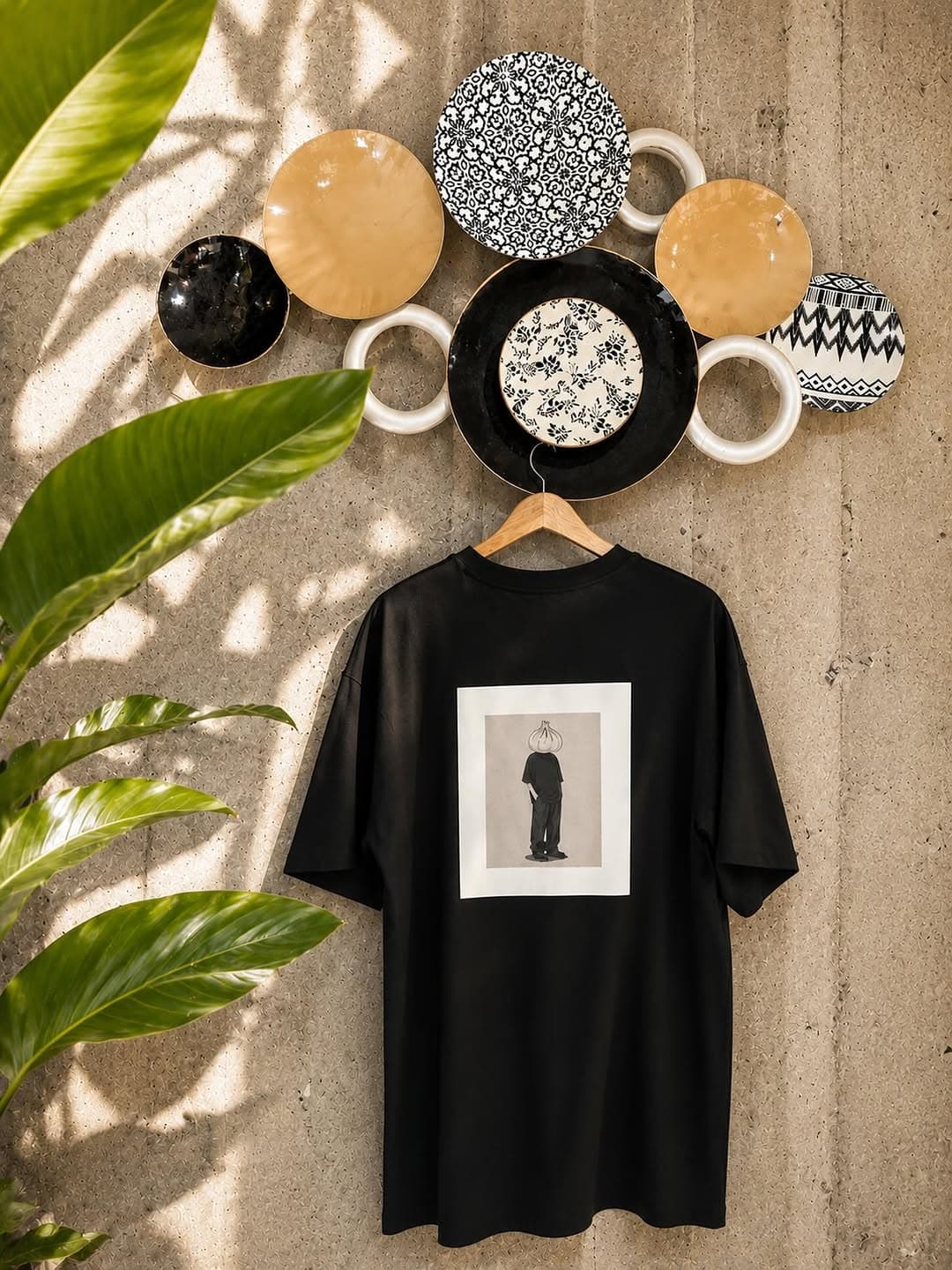 Black oversized tee with a framed gallery-style back print of a khinkali-headed figure